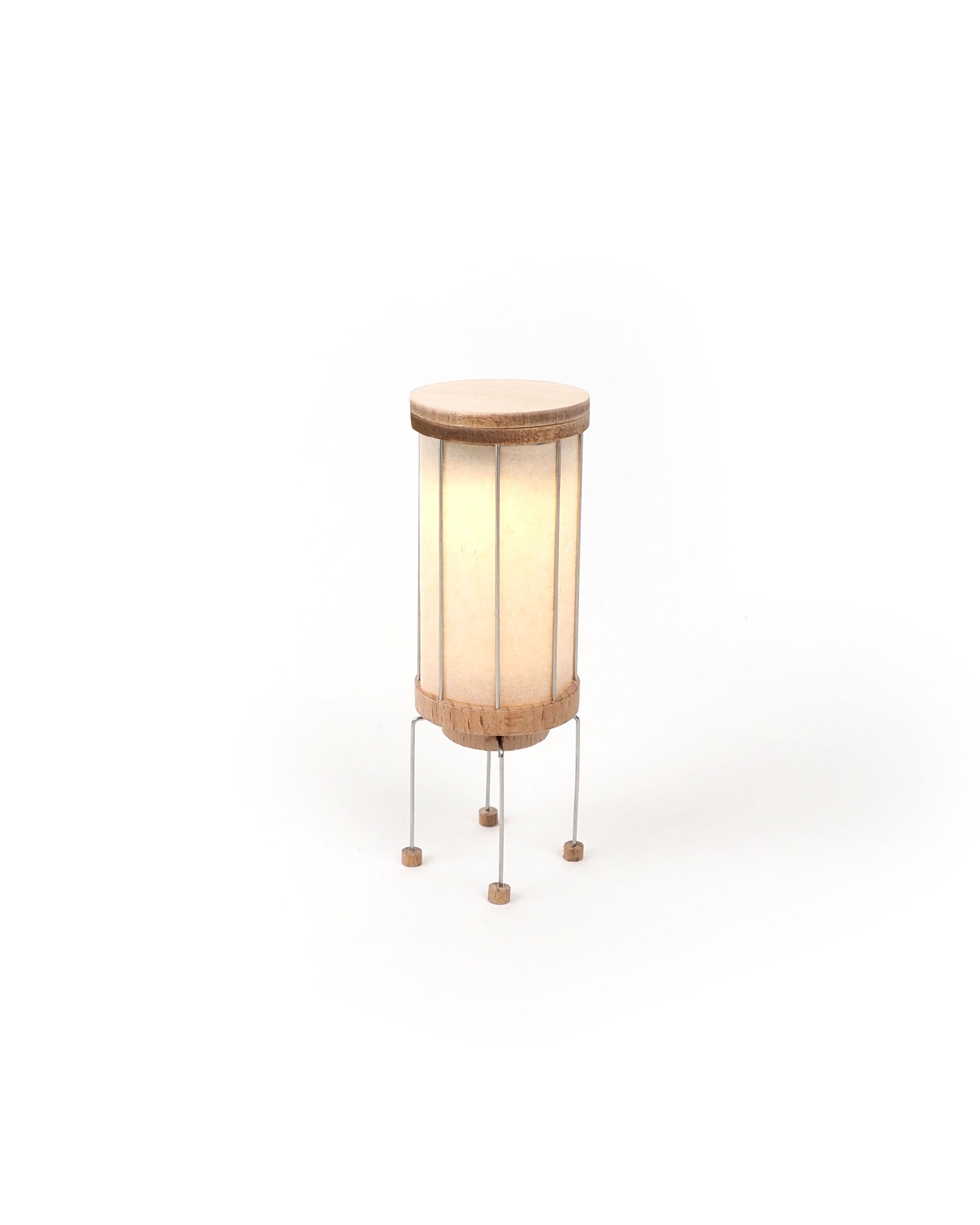 Small lamp with wooden base and white shade on a white background