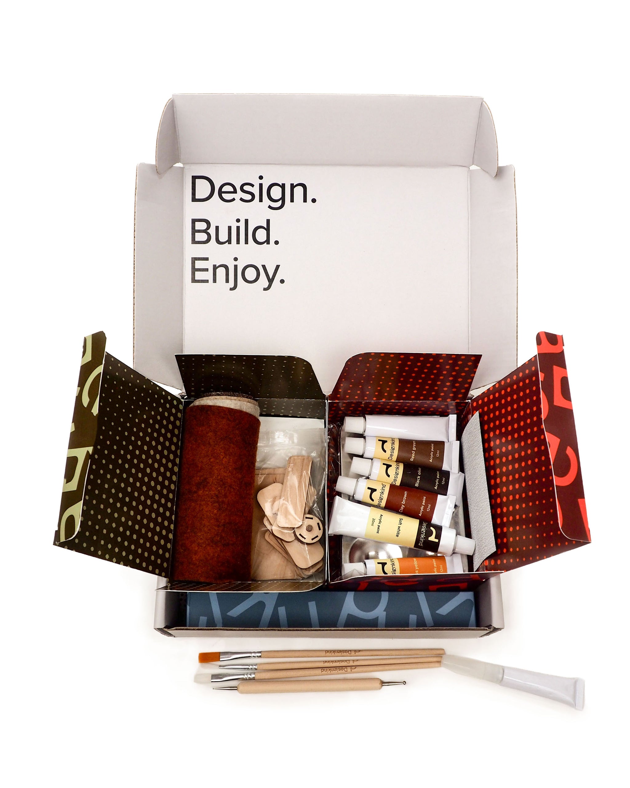 Open craft kit with tools and materials on a white background