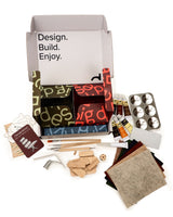 Craft kit with various materials and tools on a white background