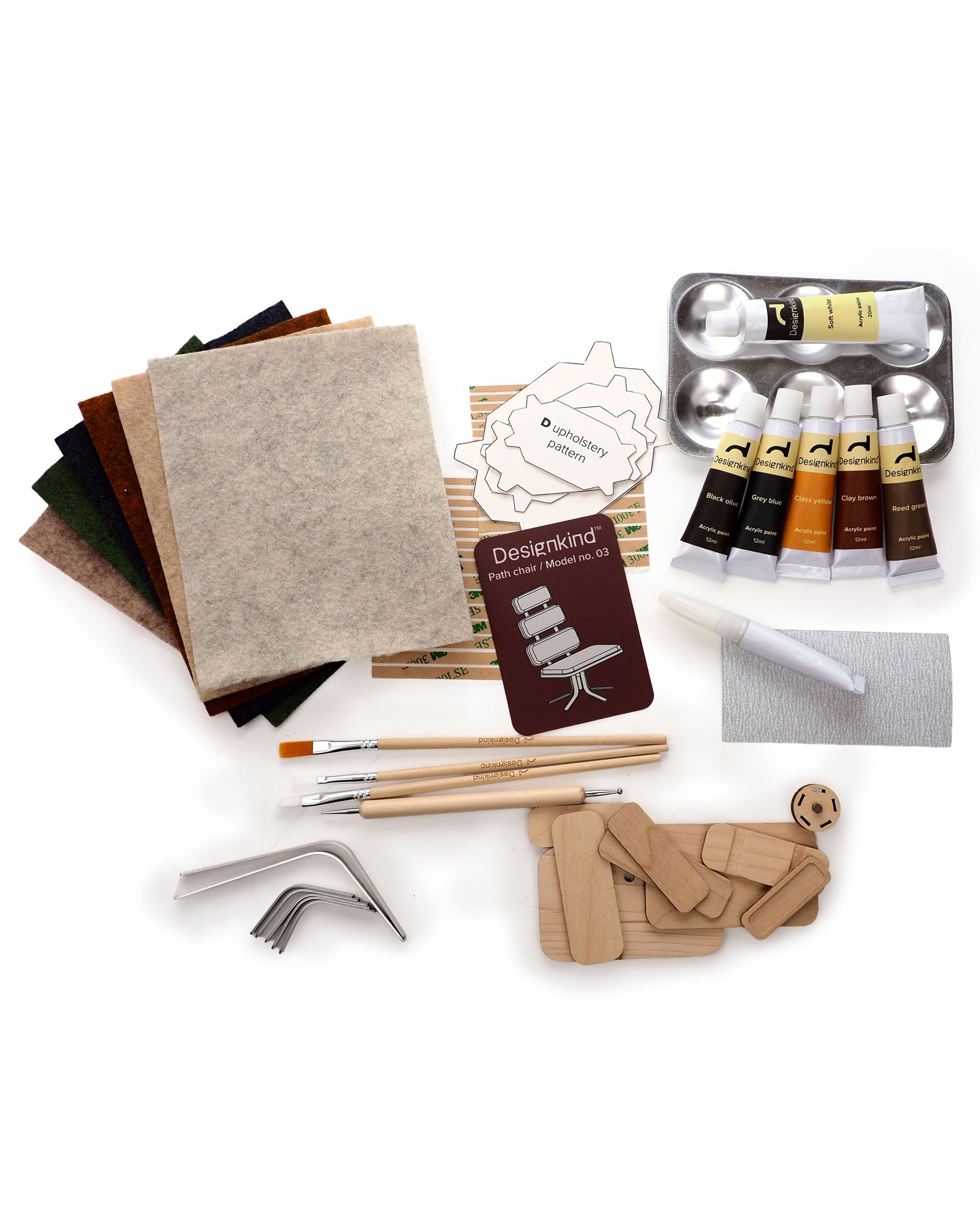 Art supplies including fabric swatches, paint tubes, brushes, and a palette on a white background