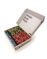Box of colorful art supplies with 'Design. Build. Enjoy.' text on a white background