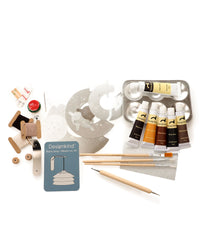 Art supplies including paint tubes, brushes, and stencils on a white background