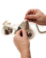 Person assembling a metal lamp on a white background